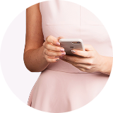 woman in a light pink dress holding a smartphone